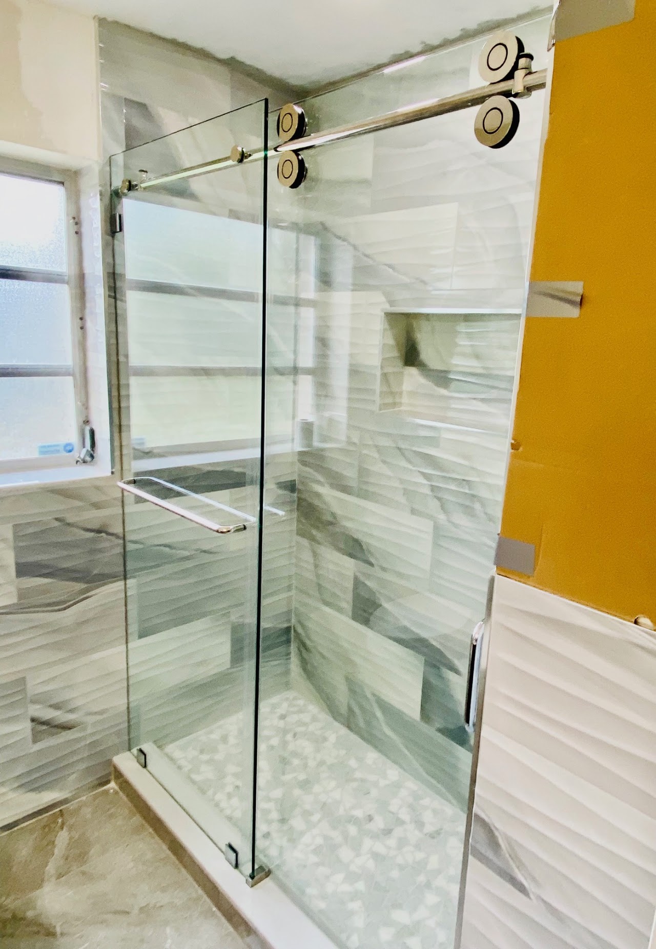 Glass shower enclosure in bright bathroom