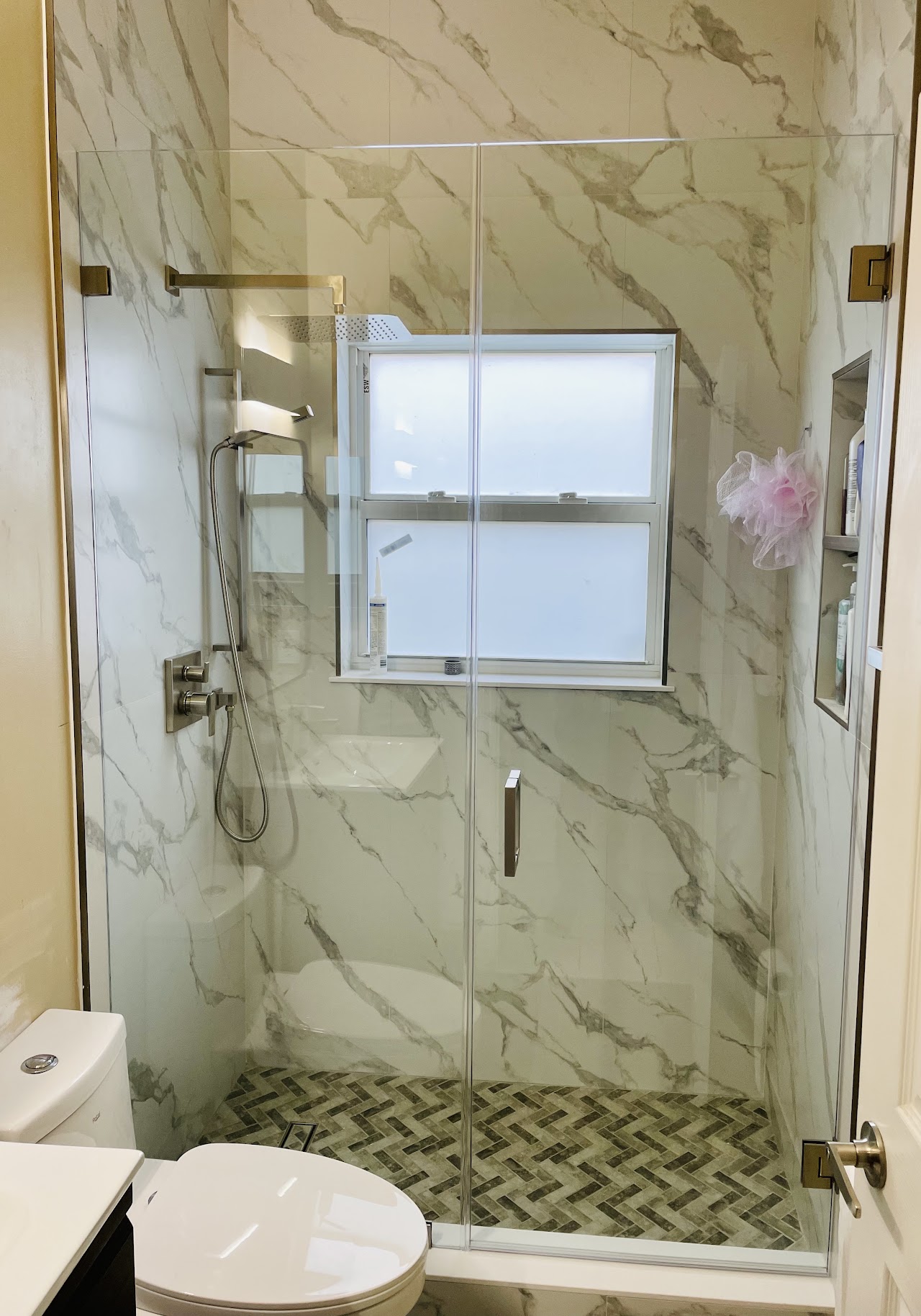 Frameless glass shower door beside window