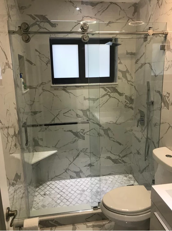 Glass shower enclosure with marble-look walls