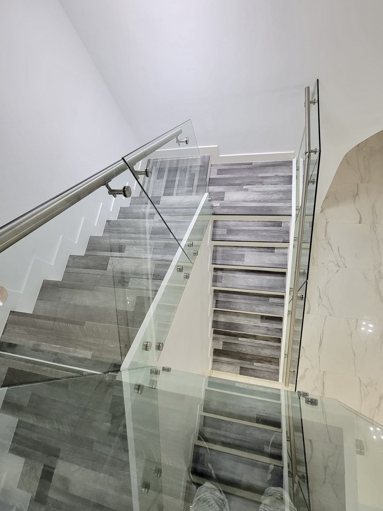 Glass railing on stairway with grey steps